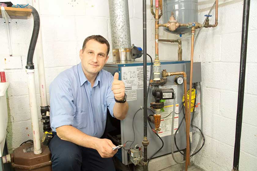 HVAC technician beside a newly installed furnace